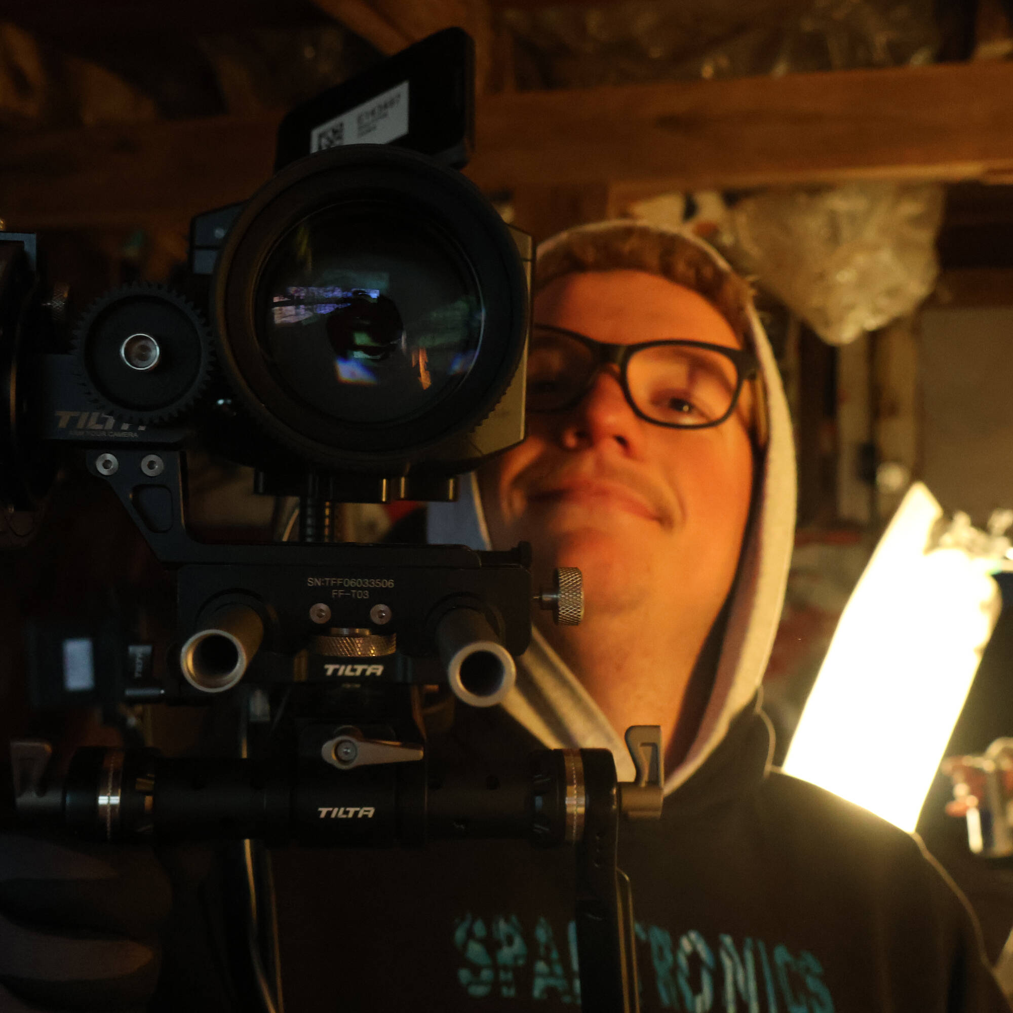 person with head tilted back behind cinema camera